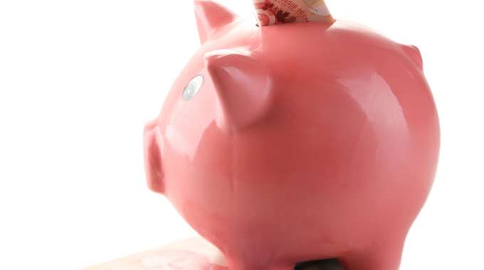 Saving money, putting cash into a piggybank.