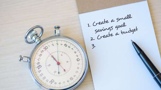 Stopwatch and notepad indicating timed productivity