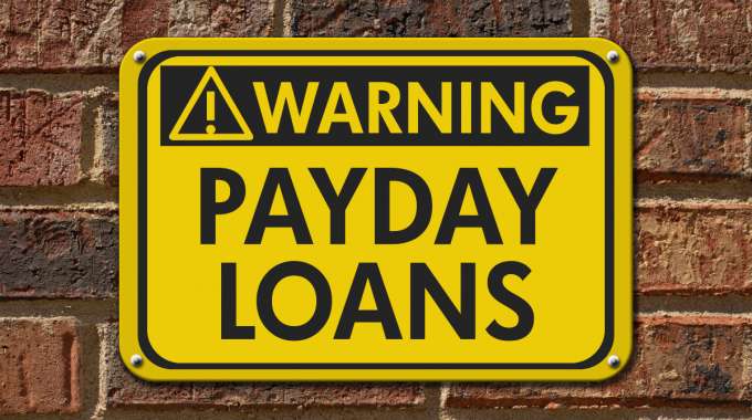 Warning sign payday loans on a brick wall