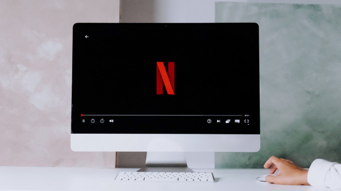 Person holding a remote about to stream content on Netflix