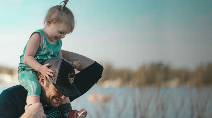 Parent with child on shoulders; enjoying family time